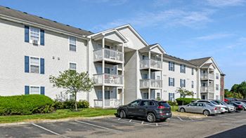 an apartment building with cars parked in front of it